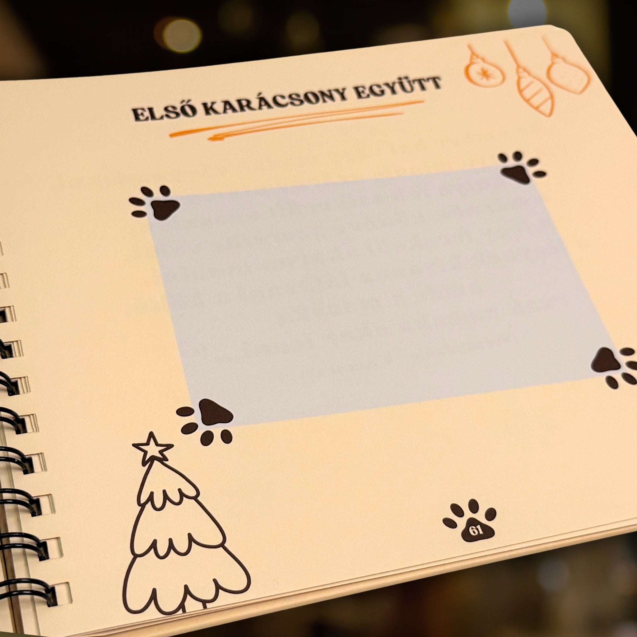 Cicanapló egyik, 61. belső oldala "Első karácsony együtt" címmel és egy beragasztható képnek kihagyott jelölő hellyel és karácsonyfával.